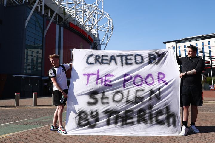 Football fans opposing the European Super League outside Manchester United's Old Trafford stadium on Monday