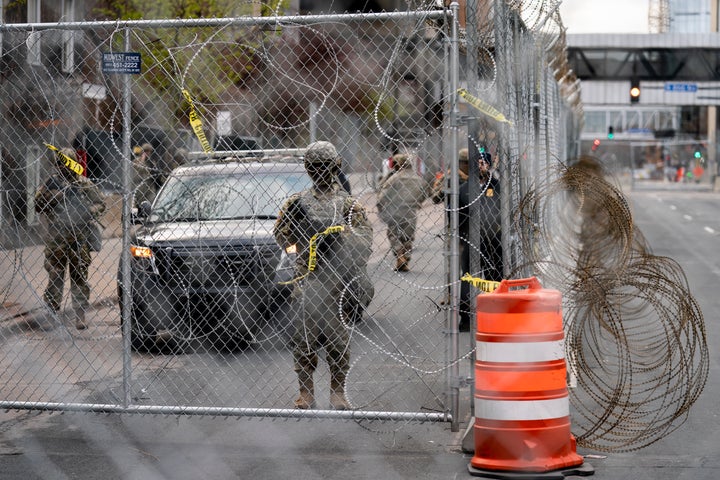 Authorities guard the Minneapolis 3rd Police Precinct as demonstrators rally outside after the murder trial against the former Minneapolis police officer Derek Chauvin in the killing of George Floyd advances to jury deliberations, Monday, April 19, 2021, in Minneapolis. (AP Photo/John Minchillo)