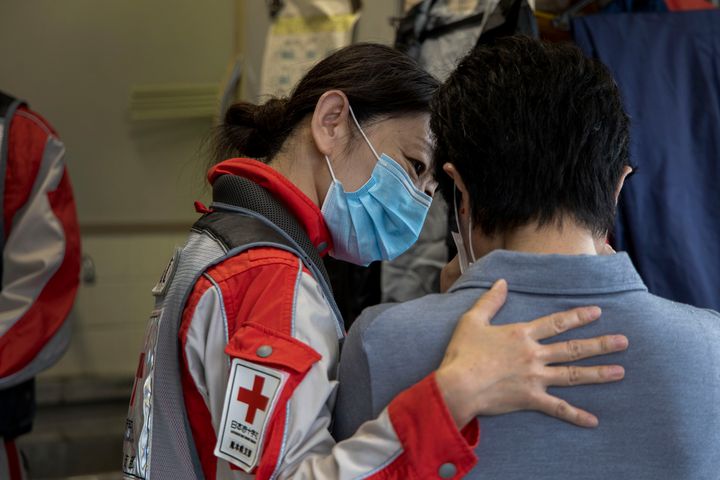2020年7月6日。看護師の肩を借りて泣く地元役場の職員。被災者の支援者でありつつ、自身も避難生活を余儀なくされていた被災者でもあった