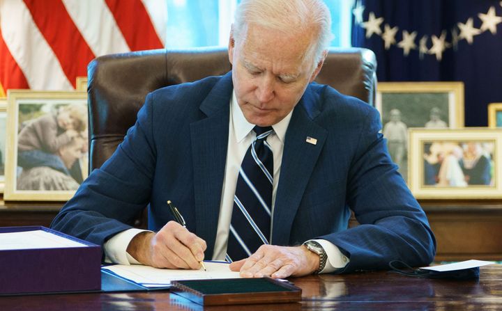 President Joe Biden signs the American Rescue Plan on March 11 in the Oval Office of the White House.