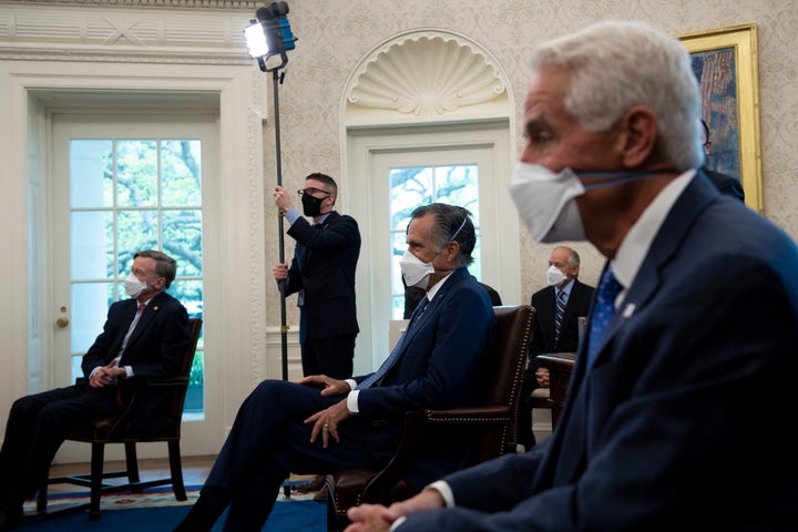 Sen. John Hickenlooper (D-Colo.), Senator Mitt Romney (R-Utah), Rep. Charlie Crist (D-Fla.), listen to President Joe Biden before a meeting about Biden's $2 trillion jobs and infrastructure plan in the Oval Office on April 19.