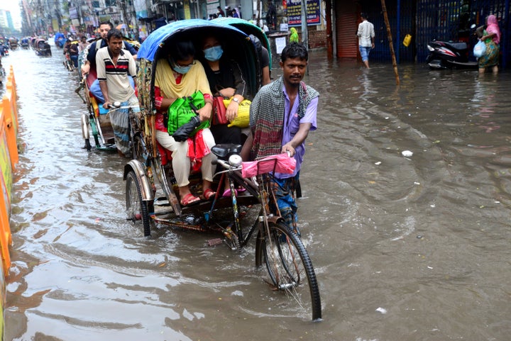 Vehicles and pedestrians slog through floodwaters in Dhaka streets in Bangladesh last October. Though Bangladesh has contributed relatively little to global emissions compared with the U.S., it faces some of the most dire consequences of global warming.