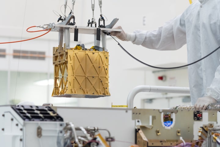 Technicians at NASA's Jet Propulsion Laboratory in La Cañada Flintridge, California, lower the Mars Oxygen In-Situ Resource Utilization Experiment (MOXIE) instrument into the belly of the Perseverance rover.