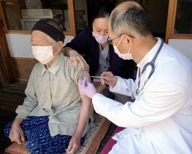 外出できないひとり暮らしの高齢者宅を訪れ、新型コロナウイルスのワクチンを注射する診療所の医師と看護師=4月21日、長野県南佐久郡北相木村