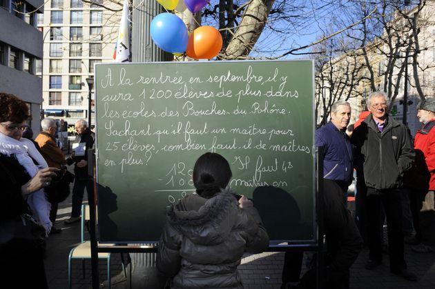 Un élève écrit au tableau lors d'un cours dans une classe installée en plein air, le 22 janvier 2011 sur la Canebière à Marseille