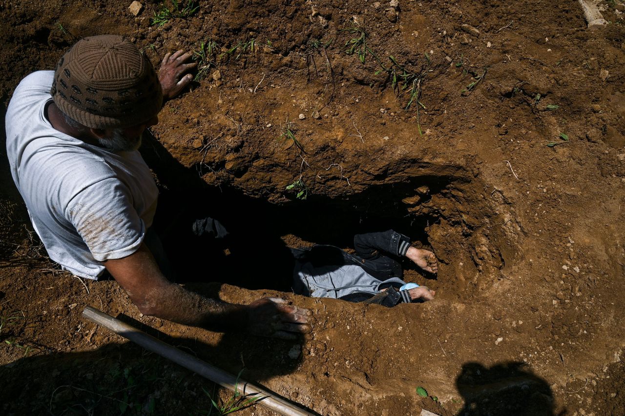 Ο Ουμάρ Φαρούκ παίρνει μέτρα για τον τάφο της μητέρας του, που πέθανε από κορονοϊό, σε νεκροταφείο στην πόλη Σριναγκάρ.