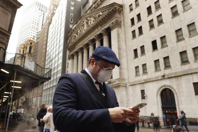 Un homme portant un masque dans le quartier de Wall Street à New York, le 13 mars 2020