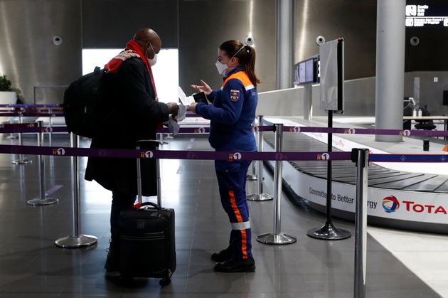 Une membre de la protection civile contrôle un voyageur le 5 février 2021 à l'aéroport de Roissy-Charles-de-Gaulle, près de Paris.