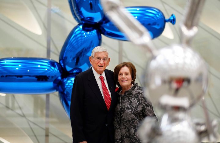 In this Sept. 16, 2015 file photo, Eli Broad and his wife, Edythe, stand for a photo amid Jeff Koons sculptures at his new mu