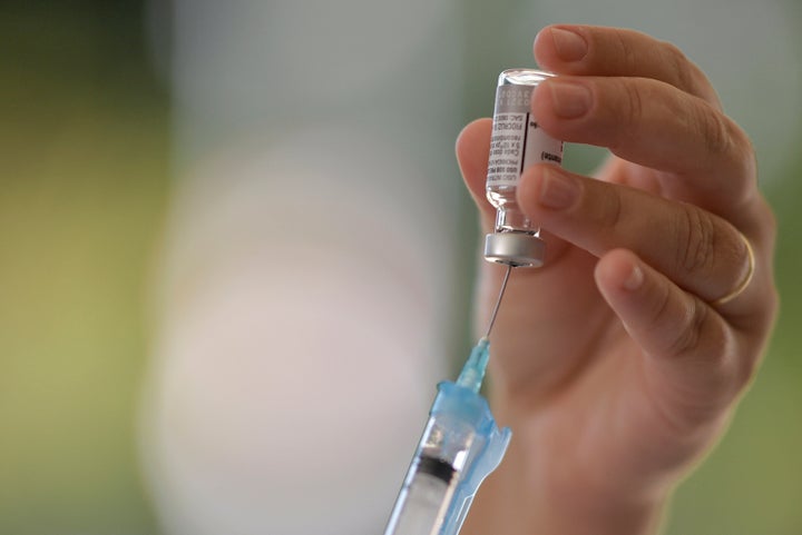 A member of the Brazilian Army prepares an AstraZeneca/Oxford vaccine. (Photo by DOUGLAS MAGNO/AFP via Getty Images)