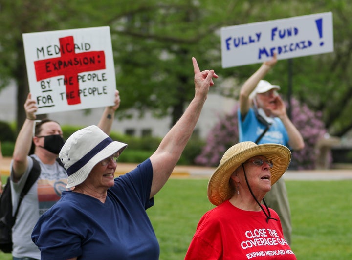 Maxine Horgan, left, and Barbara Nyden repeat the final chant of the Tuesday, April 27, 2021, Medicaid expansion rally at the