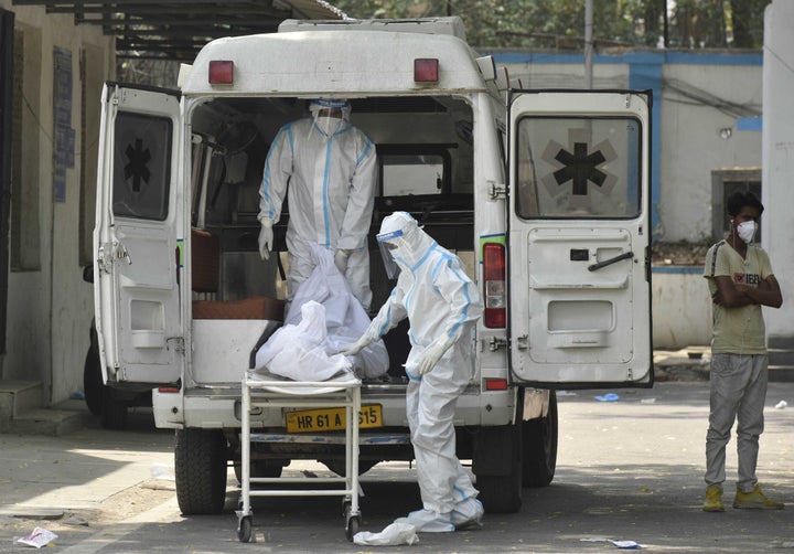 NEW DELHI, INDIA - APRIL 29: Hospital staff members shift dead body of a COVID-19 patient into an ambulance at Maulana Azad Medical College mortuary, on April 29, 2021 in New Delhi, India. (Photo by Sonu Mehta/Hindustan Times via Getty Images)