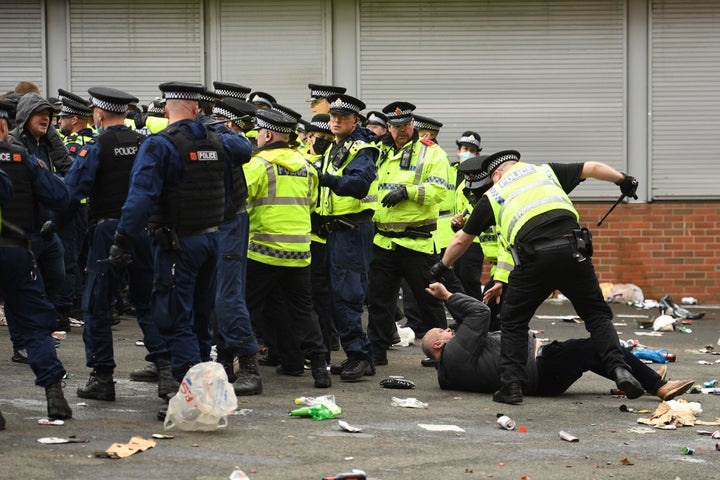 A protester falls behind the police line as police move people away from the stadium after a protest against Manchester United's owners in Manchester on May 2, 2021.(Photo by OLI SCARFF/AFP via Getty Images)