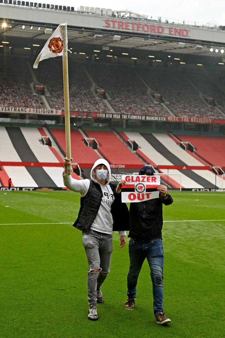 A young fan walks away with a corner flag as supporters protest against Manchester United's owners, inside English Premier League club Manchester United's Old Trafford stadium in Manchester on May 2, 2021. (Photo by OLI SCARFF/AFP via Getty Images)