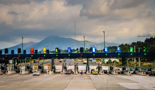 Athens, Greece-May 7, 2018- Cars stop at one of the many electronic toll gates on a highway leading to Athens, Greece
