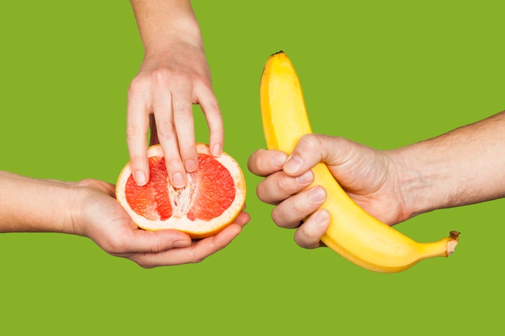 Mujer tocando su pomelo y hombre agarrando su plátano.