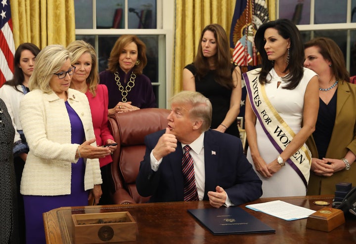 Then-President Donald Trump talks with Rep. Liz Cheney (left) after a bill-signing in the Oval Office at the White House in 2019.