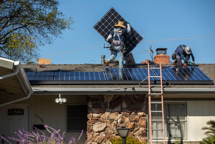 Workers install solar panels on a California home last year.