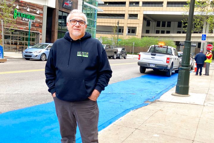 Tony Sacco, co-owner of Mootz Pizzeria and Bar in Detroit, stands on Library Street near his restaurant Wednesday, May 5, 2021. Sacco painted a portion of the street blue to clear up confusion about parking in a handicap zone that only has a single handicap sign. Sacco said it's confusing because parking enforcers consider the space reserved for as many as four vehicles. A city traffic engineer told Sacco that more signs will be installed but the blue paint will be removed. (AP Photo/Ed White)