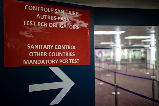 A sign indicates the way to a sanitary control point for passengers arriving from countries listed as Covid-19 red zones at the passport control area of Roissy Charles de Gaulle airport in Roissy near Paris, on April 25, 2021. - Passengers arriving in France from Brazil, Chile, Argentina, South Africa, India and Guyana must submit to a Covid-19 antigenic test and follow a 10 day quarantine at home, to curb the spread of coronavirus variants. (Photo by Ian LANGSDON / POOL / AFP) (Photo by IAN LANGSDON/POOL/AFP via Getty Images)