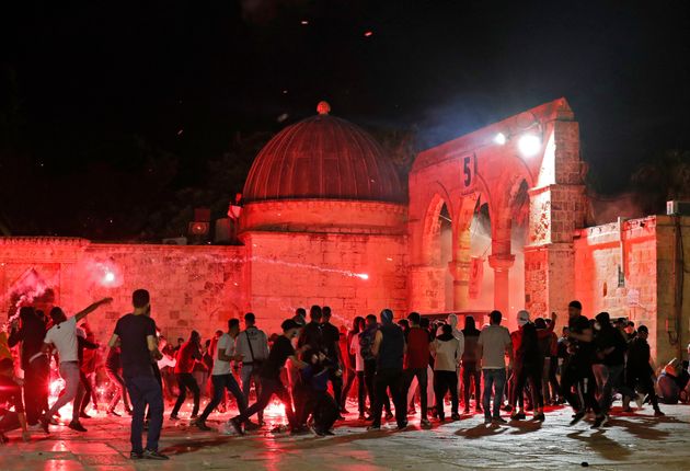 Des manifestants palestiniens lançant des pierres et des fusées éclairantes vers les forces de sécurité israéliennes dans l'enceinte de la mosquée al-Aqsa, à Jérusalem, le 7 mai 2021.