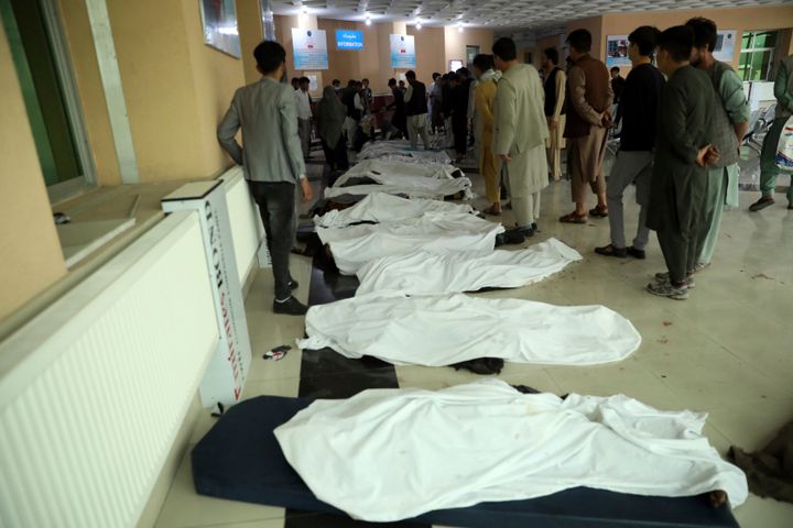 Afghan men try to identify the dead bodies at a hospital after a bomb explosion near a school west of Kabul, Afghanistan, Saturday, May 8, 2021. (AP Photo/Rahmat Gul)