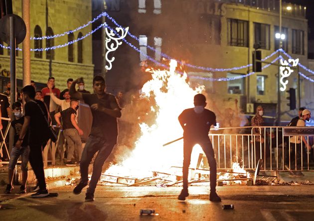 Des Palestiniens envoyant des pierres sur des policiers israéliens à Jérusalem, le 8 mai 2021.