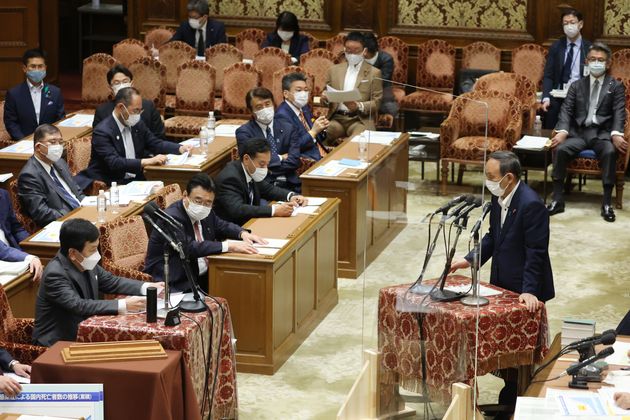衆院予算委員会で、立憲民主党の枝野幸男代表（左下）の質問に答弁する菅義偉首相（右）