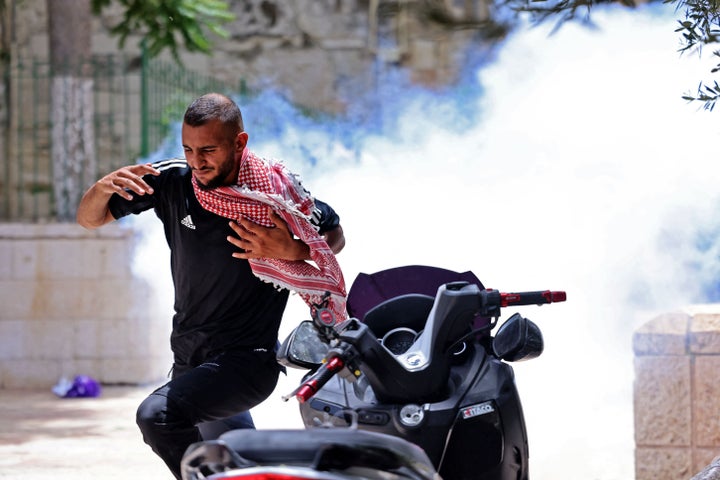 A Palestinian protester runs for cover from tear gas fired by Israeli security forces in Jerusalem's Old City on May 10, 2021