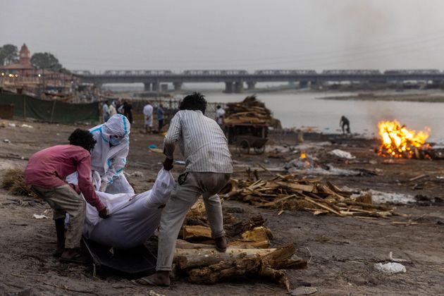 Des hommes ramassent des victimes présumées du Covid-19 sur les rives du Gange en Inde le 6 mai 2021