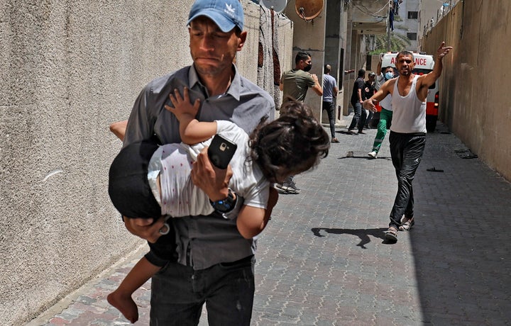 Palestinians evacuate a building targeted by Israeli bombardment in Gaza City on May 11, 2021. 