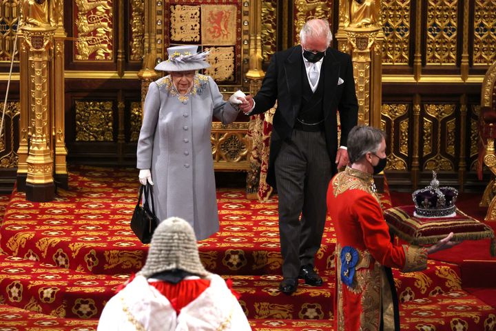 Une image montrant la couronne de la reine transportée dans la chambre devant elle sur un coussin.