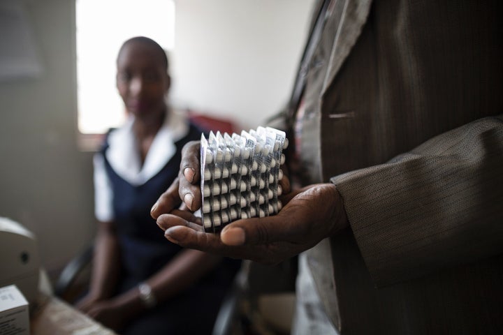 An HIV-positive patient in Malawi holds a month's worth of medication in Nov. 2014. Public health advocates credit the loosen