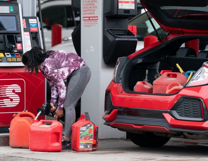 A woman fills up several gasoline cans Wednesday at a Speedway gas station in Benson, North Carolina. Most stations in the area along Interstate 95 were without fuel following the Colonial Pipeline hack. 