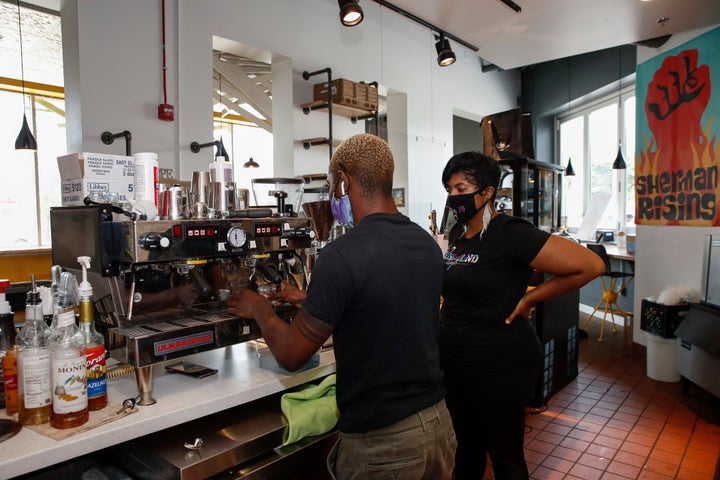 Baboonie Tatum, owner of the Rise & Grind Cafe, checks on an employee inside her coffee shop in Milwaukee on Aug. 15, 202