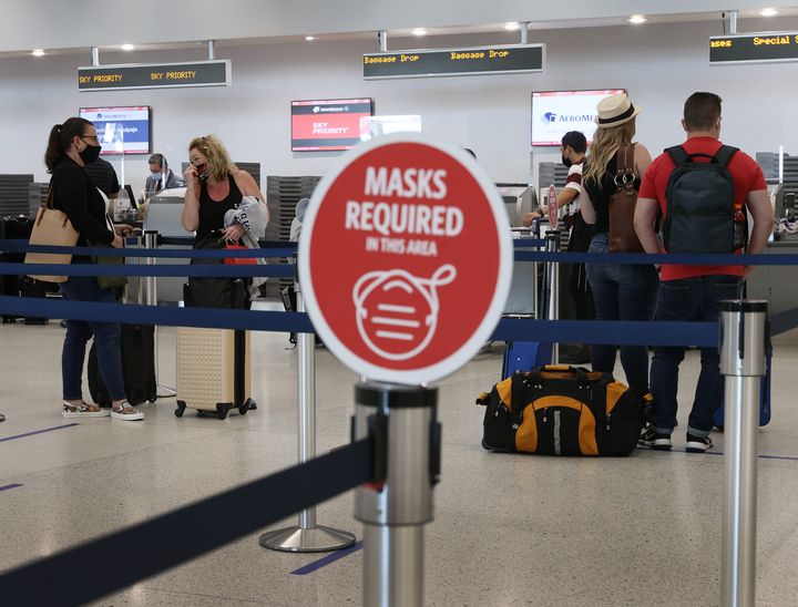 1 Φεβρουαρίου 2021. Φλόριντα, Μαϊάμι. Ταξιδιώτες ετοιμάζονται για να επιβιβαστούν σε πτήση της Delta ενώ σε πρώτο πλάνο ξεχωρίζει η προειδοποίηση για χρήση μάσκας. (Photo by Joe Raedle/Getty Images)
