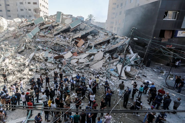 Palestinians inspect the remains of Al-Jalaa tower, which housed several media outlets including The Associated Press and Al 