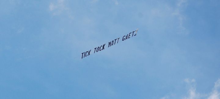 An airplane flies with a banner in tow reading "Tick Tock Matt Gaetz" over the United States Federal Court House on May 17, 2021 in Orlando, Florida.
