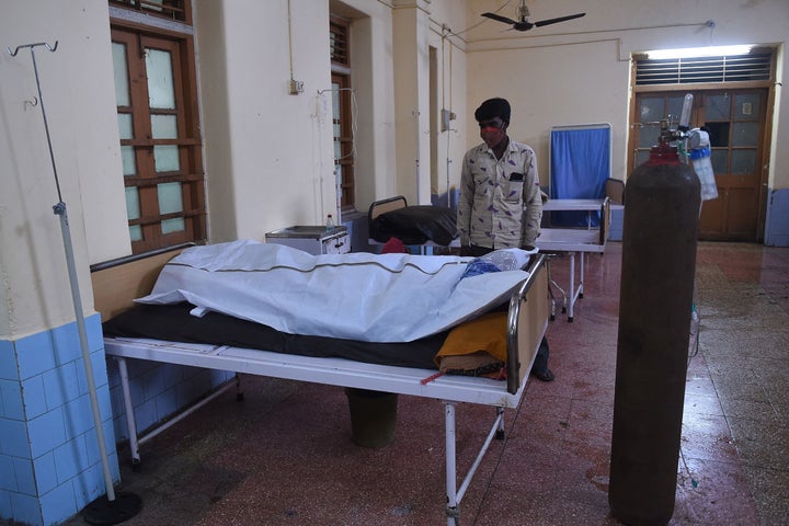 A family member mourns next to the body of a COVID-19 victim in a hospital in Mahua on May 18, 2021.