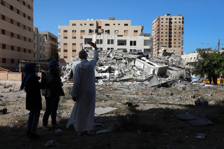 A Palestinian man stands near the remains of a building after it was destroyed in Israeli air strikes in Gaza City on May 18, 2021. 