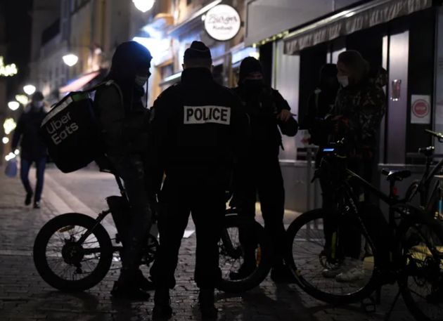 Un policier vérifiant l'attestation d'un coursier pendant le couvre-feu. Image d'illustration.