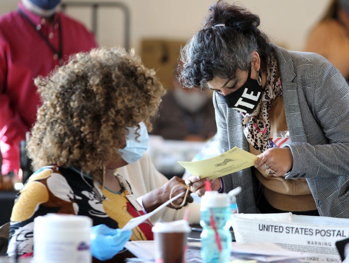 Fulton County election workers examine ballots while vote counting at State Farm Arena on Nov. 5, 2020, in Atlanta, Georgia.