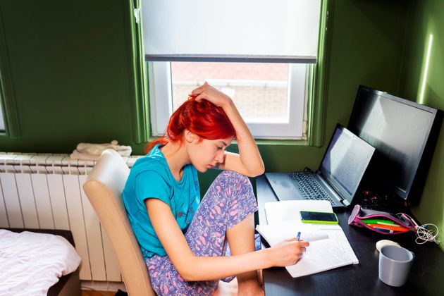 Photo of highschool girl at home. Distance learning, online education. A teenage girl studies at home and does school homework. A home distance learning.