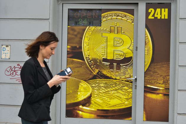 Una mujer pasa por delante de un local de cambio de Bitcoin en Cracovia