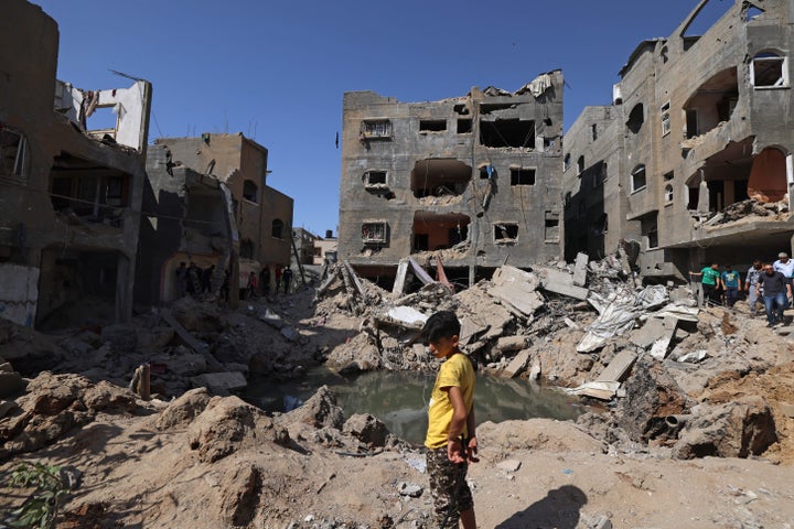 A Palestinian child stands amid the rubble of buildings, destroyed by Israeli strikes, in Beit Hanoun in the northern Gaza Strip on Friday.