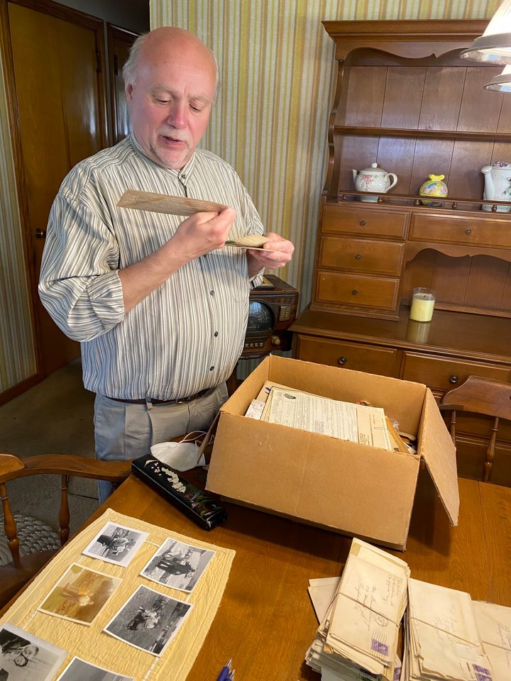 遺された手紙や写真を保存ボックスから取り出して見入るデビッドさん＝2021年5月、Davidさんの自宅。福山万里子さん撮影