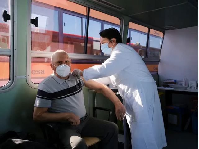 Ένας κάτοικος της Βενετίας κάνει το εμβόλιο στο παραδοσιακό "βαπορέτο", το φέρι μποτ που χρησιμοποιείται ως δημόσια συγκοινωνία.
