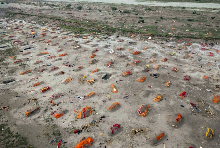 SHRINGVERPUR, INDIA - MAY 20: (EDITOR'S NOTE: Image depicts death.) Bodies, some of which are believed to be Covid-19 victims, are seen partially exposed in shallow sand graves after rains washed away the top layer of sand at a cremation ground on the banks of the Ganges River on May 20, 2021 in Shringverpur, northwest of Allahabad, Uttar Pradesh, India. Gravediggers at the site said that there was a threefold increase in the number of bodies arriving for burials and cremations since April. Teams of police and local officials have been patrolling several areas along the river in Uttar Pradesh and Bihar to discourage burials on its banks, and to warn people of possible infection risks, local media reported. India's prolonged and debilitating wave of Covid-19 infections has reached deep into rural India, where the true extent of devastation may never be known because of a lack of widespread testing or reliable data. (Photo by Ritesh Shukla/Getty Images)