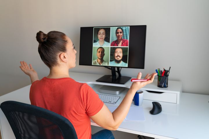 Una mujer gesticula durante una reunión de trabajo por videoconferencia.