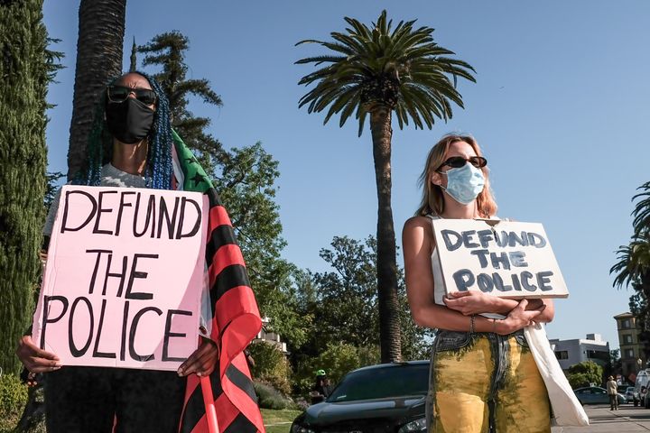 Protesters hold placards during a demonstration in April outside of Los Angeles Mayor Eric Garcetti's home to protest his proposal to restore funding to the Los Angeles Police Department.